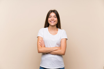 Pretty young girl over isolated background keeping the arms crossed in frontal position