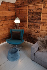 Scandinavian cozy style. Living style. Stylish armchair with light for reading and sofa.
