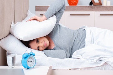 Young woman lying on the bed in time management concept