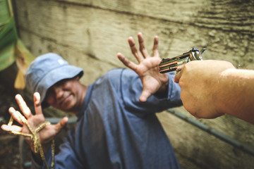 The man lifted his hand to surrender, because the robber carrying a revolver was about to rob him.