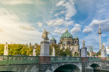 Beautiful sunset over the access to the Museum Island complex through the Schloss bridge and its statues, with the Berliner Dom and the TV Tower in the background