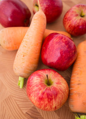 Food. Аpples and carrots, wooden background