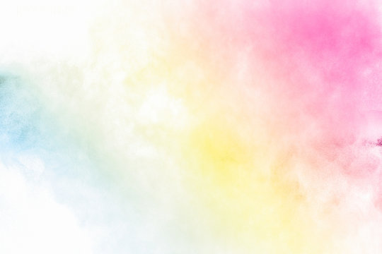 The explosion of multi colored powder. Beautiful rainbow color powder fly away. The cloud of glowing color powder on white background