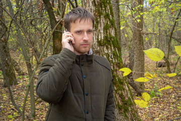 man is talking on the phone in the woods