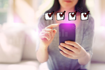 Checklist with woman using her smartphone in a living room