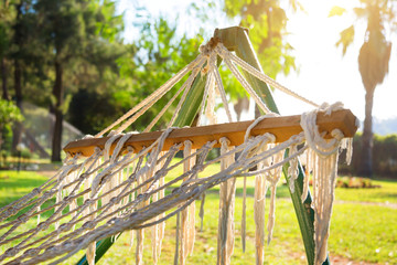 A hammock for relaxing among palm trees. Close-up a stretched hammock net for relaxing in the shade of trees at dawn.