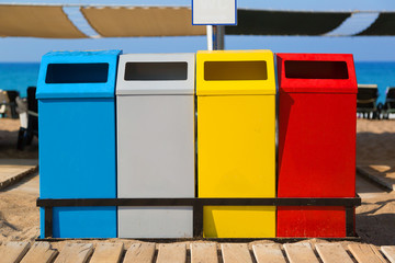 Garbage containers on the beach. Tanks containers of different colors for separate collection of waste and garbage on the sea beach.