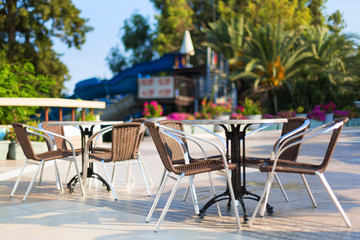 Free tables and chairs of a summer restaurant on the terrace in the open air Empty tables of the summer restaurant of the hotel.
