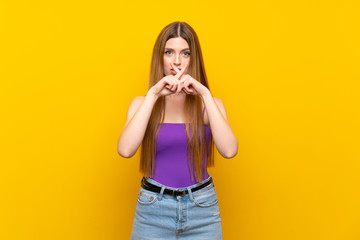 Young woman over isolated yellow background showing a sign of silence gesture