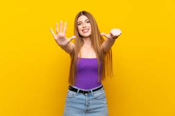 Young woman over isolated yellow background counting six with fingers