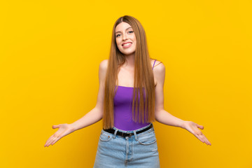 Young woman over isolated yellow background smiling