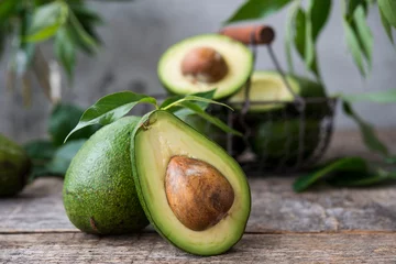 Foto op Plexiglas Verse groene avocado op houten achtergrond. Selectieve aandacht. Horizontale oriëntatie. © Evgenija