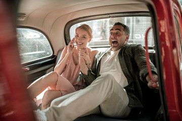 Scared man holding hand of his wife in the car.