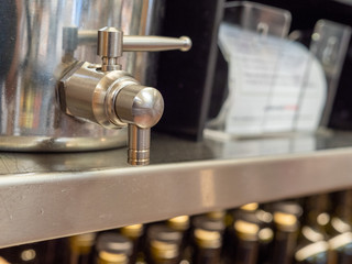 Steel beverage dispenser handle in closed position sitting on shelf