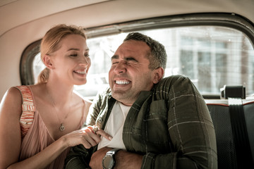 Husband and wife having fun tickling in the car.