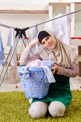 Woman in hijab doing clothing ironing at home