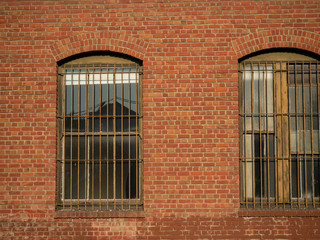 Multiple weathered gates and windows outside of brick warehouse