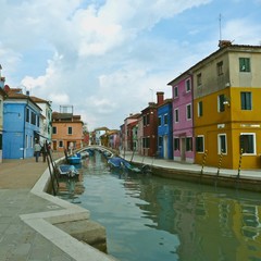 Canal in Murano/Burano in Venice, Italy. Beautiful colored house and small boats. Sunny day, great for tourism