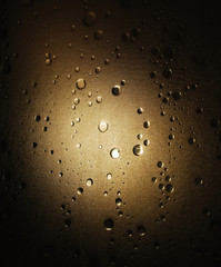 Light shines through a plastic shower door with a bubble-effect surface