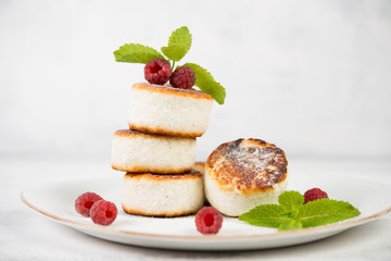 Delicious cheesecakes pancakes, decorated with fresh berries and mint. Horizontal orientation.