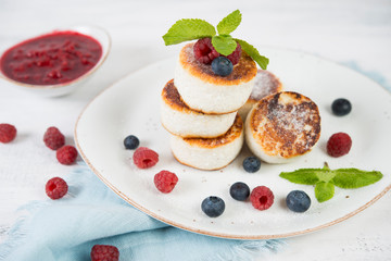 Delicious cheesecakes pancakes, decorated with fresh berries and mint. Horizontal orientation.