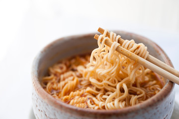 Closeup hot and spicy instant noodle in clay bowl.