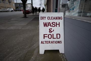 Dry cleaning wash and fold alterations signboard outside of store on sidewalk