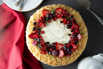 Homemade sponge cake with cream and fresh berries. Carrot and orange cake, decorated with berry. sweet dessert. Whole deliciouse cake. Gray background.