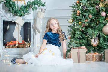 portrait of a girl in Christmas decorations. child enjoy the holiday near Christmas tree. 