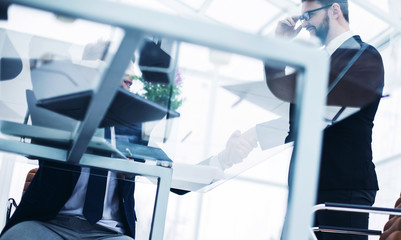 bottom view - the handshake of employees in the workplace in a modern office.