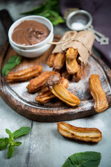 Traditional Spanish dessert. Churros with chocolate. Vertical photo.