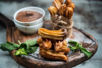 Traditional Spanish dessert. Churros with chocolate and powdered sugar