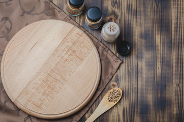Various spices, cutting board and cooking utensils on wooden background. Top view with space