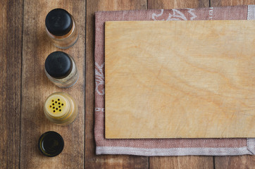 Various spices, cutting board and cooking utensils on wooden background. Top view with space