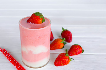Strawberry smoothies pink colorful fruit juice beverage healthy high protein the taste yummy in glass on white wood background.