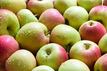 Drops of water on ripe apples. A lot of apples as a background.