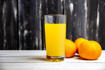 oranges and orange juice on wooden background