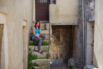 Obraz na płótnie Canvas Young woman on the stairs of a old Croatian city.