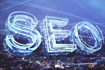 SEO hologram on city view with skyscrapers background double exposure. Search optimization concept.