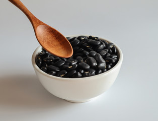 Black beans in a white cup on a white background