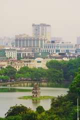 Fototapeta na wymiar OLD QUARTER, HANOI/VIETNAM City and top view of The Huc bridge and Ngoc Son temple in Lake of the Returned Sword, Hoan Kiem Lake, Turtle Tower. Cities with haze problems