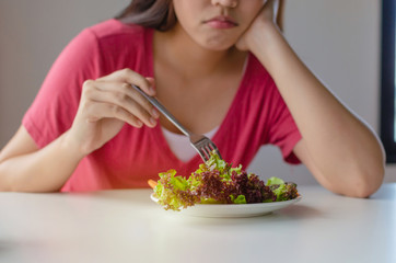 Diet. asian young pretty woman bored emotion and refuse for eating fresh green vegetables salad on...