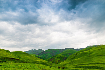 Obraz premium Blue beautiful clouds over the green picturesque mountains of Armenia