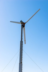 Fototapeta na wymiar Windmill power generator against blue sky