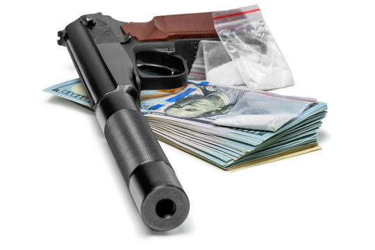 crime concept - a pistol with a silencer, money and drugs close up