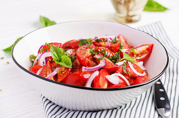 Tomato salad with basil and red onions. Homemade food.  Concept healthy meal. Vegan cuisine.