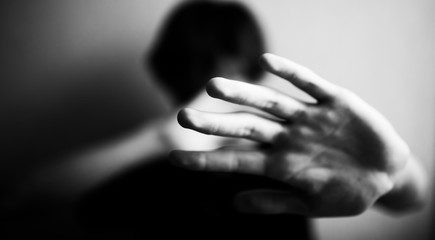 Teen boy protects himself with open palm