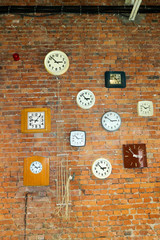 Composition of old vintage clock on the red brick wall
