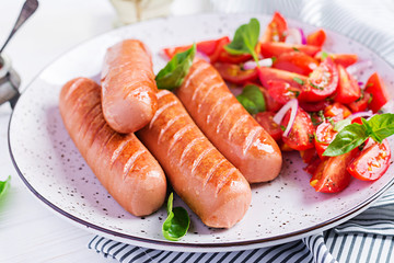 Grilled sausage with tomatoes, basil salad and red onions. BBQ menu.