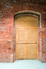 old wooden door in vintage brick wall